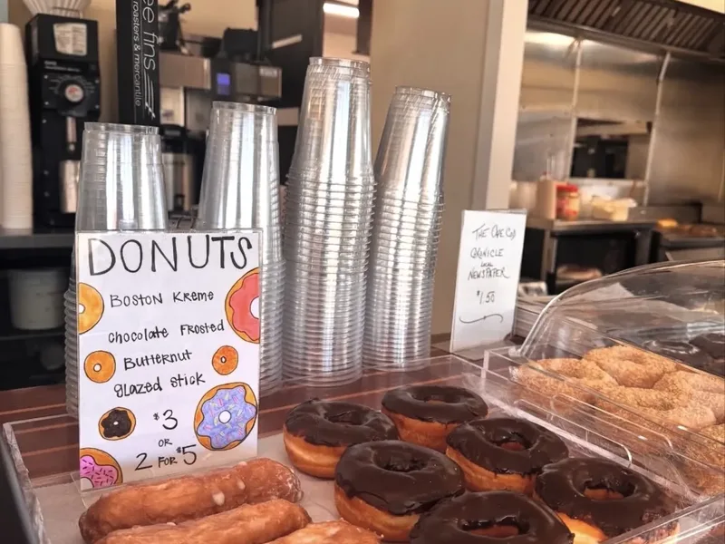 A tray of glazed and chocolate frosted doughnuts by the counter