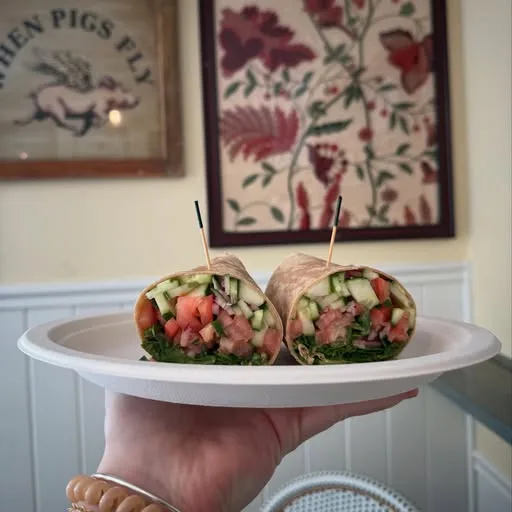 A salad wrap cut in half and stood up on a cake stand